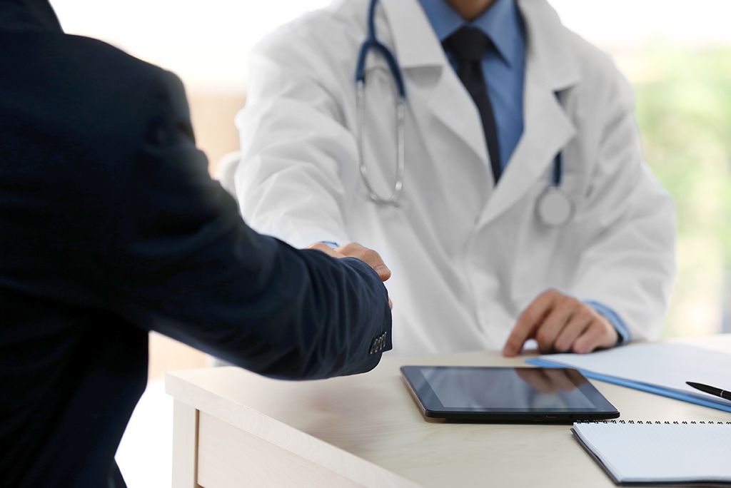 physician discussing own-occupation disability insurance with advisor agent